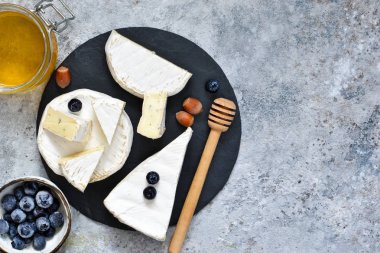 Gurme beyaz brie peyniri veya çilek, bal ve fındık bir beton zemin üzerine ile camembert.