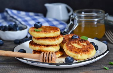 Klasik Rus kahvaltı - cheesecake bal ve çilek ile.