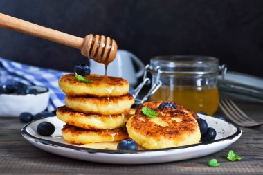 Klasik Rus kahvaltı - cheesecake bal ve çilek ile.