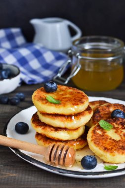 Klasik Rus kahvaltı - cheesecake bal ve çilek ile.