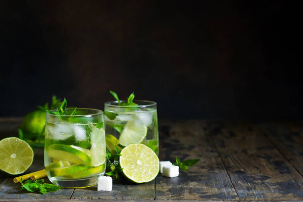 Cold alcohol mahito with mint and lime on a dark background. Summer drink.