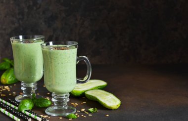 Avokado, salatalık, fesleğen ve granola karanlık taşlı zemin üzerine yeşil smoothies. Diyet İçecek.