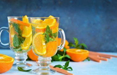 Soğuk yaz içeceği. Nane ve mavi bir arka plan üzerinde turuncu ile limonata.