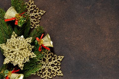 Noel ağacı ve dekoratif kar taneleri, çan, kurdeleler metnin altına alan bir kahverengi zemin üzerine.