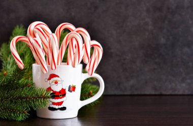 Yeni yıl gıda arka plan. Baston şekerler metnin altına alan siyah bir zemin üzerine bir fincan.