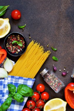 İtalyan yemeği arka plan. Makarna yemek pişirmek için malzemeler: spagetti, domates, fesleğen, karabiber karanlık bir beton zemin üzerine.