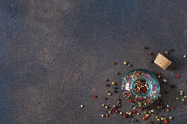 Kırmızı, siyah ve beyaz biber karışımı. Biber bir kavanoza bir beton zemin üzerine çeşitli.