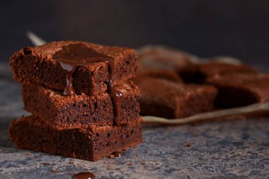 Brownie bir klasik Amerikan tatlı var. Karanlık bir arka plan üzerinde çikolata soslu pasta.