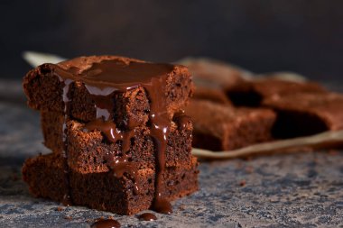 Brownie bir klasik Amerikan tatlı var. Karanlık bir arka plan üzerinde çikolata soslu pasta.