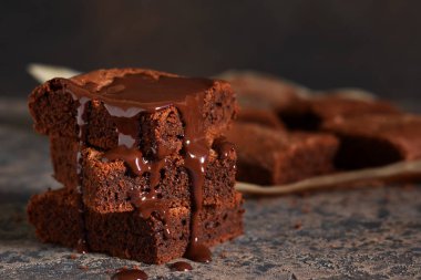 Brownie bir klasik Amerikan tatlı var. Karanlık bir arka plan üzerinde çikolata soslu pasta.