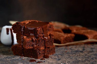 Brownie bir klasik Amerikan tatlı var. Karanlık bir arka plan üzerinde çikolata soslu pasta.