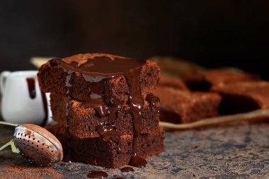 Brownie bir klasik Amerikan tatlı var. Karanlık bir arka plan üzerinde çikolata soslu pasta.