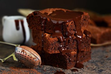 Brownie bir klasik Amerikan tatlı var. Karanlık bir arka plan üzerinde çikolata soslu pasta.
