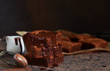Brownie bir klasik Amerikan tatlı var. Karanlık bir arka plan üzerinde çikolata soslu pasta.