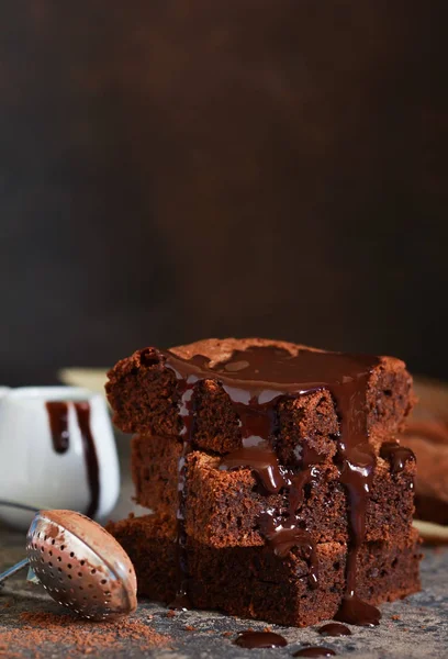 Brownie bir klasik Amerikan tatlı var. Karanlık bir arka plan üzerinde çikolata soslu pasta.