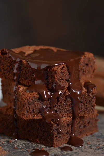 Brownie bir klasik Amerikan tatlı var. Karanlık bir arka plan üzerinde çikolata soslu pasta.