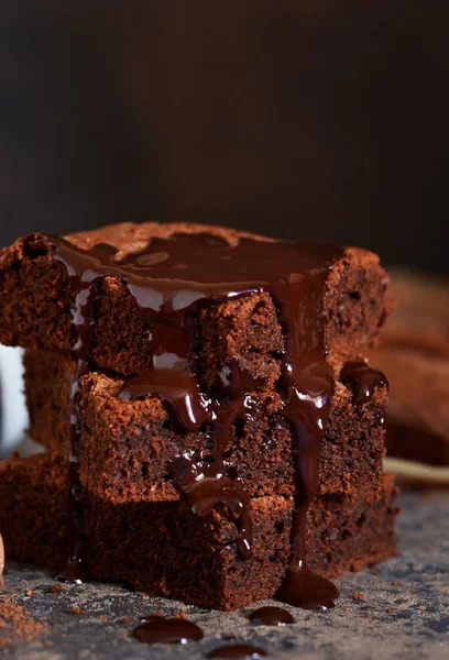 Brownie bir klasik Amerikan tatlı var. Karanlık bir arka plan üzerinde çikolata soslu pasta.