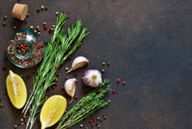 Gıda arka plan - baharat. Baharat kümesi: biber, kırmızı biber, sarımsak, tuz, limon, biberiye, kekik ve zeytinyağı bir beton zemin üzerine.