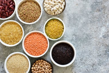 Kase tahıl varyasyonu: fasulye, pirinç, nohut, bezelye bir beton zemin üzerine.