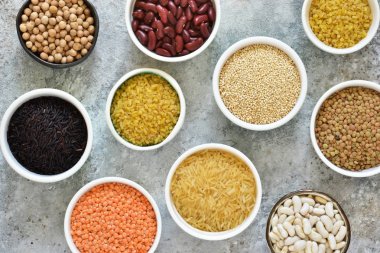 Kase tahıl varyasyonu: fasulye, pirinç, nohut, bezelye bir beton zemin üzerine.