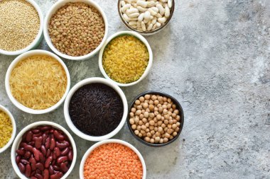 Kase tahıl varyasyonu: fasulye, pirinç, nohut, bezelye bir beton zemin üzerine.