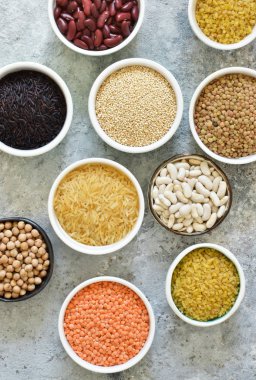 Kase tahıl varyasyonu: fasulye, pirinç, nohut, bezelye bir beton zemin üzerine.