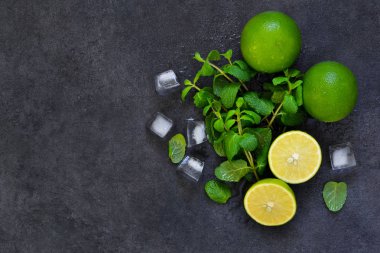 Siyah arka planda taze nane, kireç ve buz. Mahito 'nun malzemesi. Üst görünüm