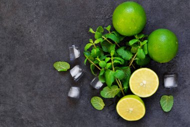 Siyah arka planda taze nane, kireç ve buz. Mahito 'nun malzemesi. Üst görünüm