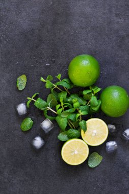 Siyah arka planda taze nane, kireç ve buz. Mahito 'nun malzemesi. Üst görünüm