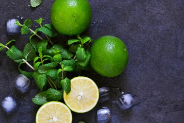 Siyah arka planda taze nane, kireç ve buz. Mahito 'nun malzemesi. Üst görünüm