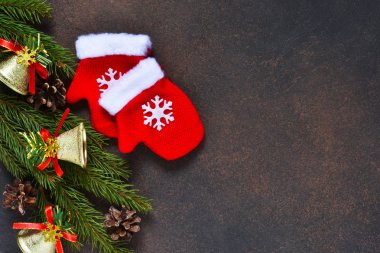 Dekorasyon ve kahverengi bir arka plan ile yer metnin altına mittens ile Noel ağacı.