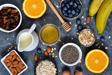 Gıda arka plan. Kahvaltı için malzemeler: granola, badem, bal, meyve ve çilek bir beton zemin üzerine.