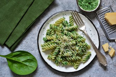 Rotini beton zemin üzerine parmesan ve ıspanak soslu makarna. Gıda arka plan. Üstten görünüm.