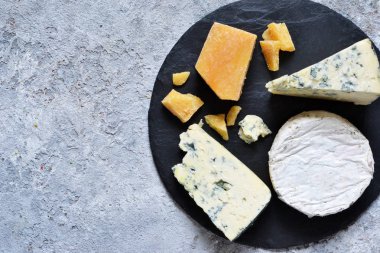 Peynir bir dizi: brie, mavi peynir, parmesan, camembert kayrak bir gemide. Plaka lezzetleri ile. Yukarıdan görüntülemek