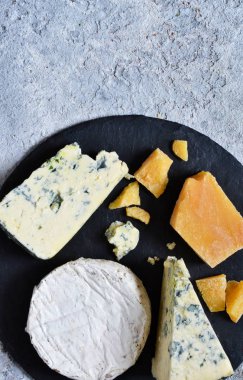 Peynir bir dizi: brie, mavi peynir, parmesan, camembert kayrak bir gemide. Plaka lezzetleri ile. Yukarıdan görüntülemek