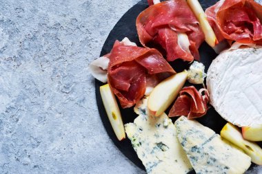 Kayrak lezzetleri ile plaka: jamon, mavi peynir, brie. Yukarıdan görüntülemek.