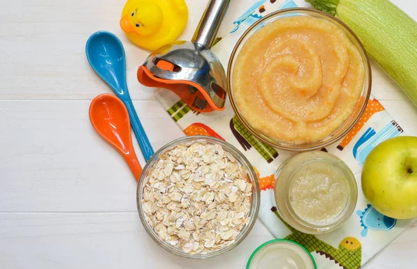 Baby food from 6 months. Vegetable puree from courgettes, stamps and potatoes on a concrete background. Food for newborns.