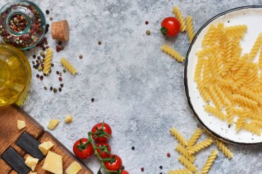 İtalyan yemeği arka plan. Makarna, domates, parmesan ve baharat bir beton zemin üzerine. Yemek pişirmek için madde.
