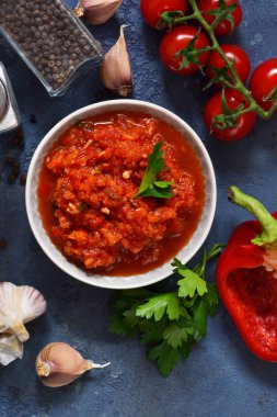 Domates soslu biber, baharatlar ve otlar mutfak masasının üzerinde. Yukarıdan görüntülemek.