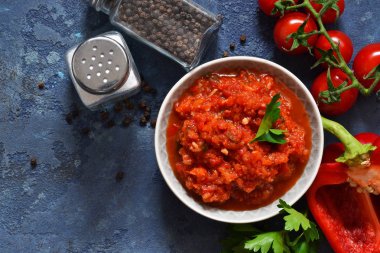 Domates soslu biber, baharatlar ve otlar mutfak masasının üzerinde. Yukarıdan görüntülemek.