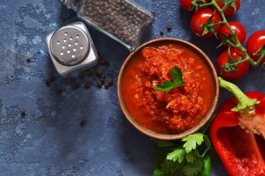 Domates soslu biber, baharatlar ve otlar mutfak masasının üzerinde. Yukarıdan görüntülemek.