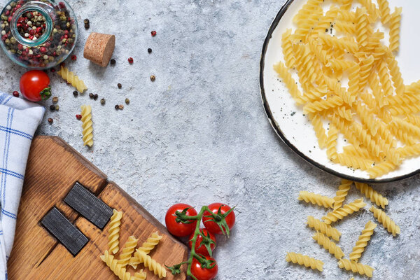 Italian food background. Pasta, tomatoes, parmesan and spices on a concrete background. Ingredient for cooking.