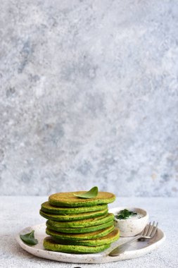 Yeşil hafif bir beton zemin üzerine ıspanaklı krep. 