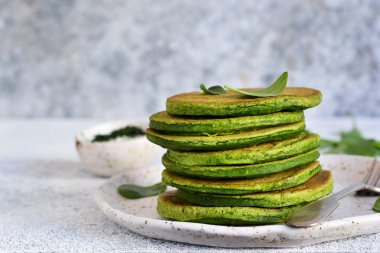 Yeşil hafif bir beton zemin üzerine ıspanaklı krep. 