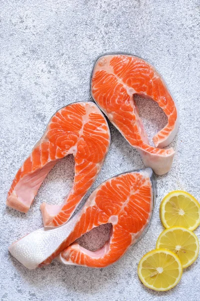 Fresh, raw salmon with lemon on a white concrete background. — Stock Photo, Image