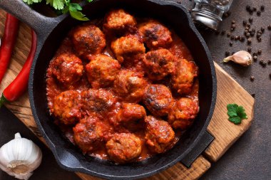 Mutfak masasının üzerinde tatlı ve ekşi domates soslu köfte. 
