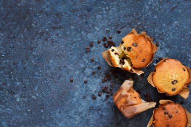 Bir beton üzerinde çikolata damlaları ile kağıt şeklinde vanilya kekler