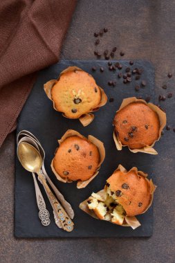 Bir beton üzerinde çikolata damlaları ile kağıt şeklinde vanilya kekler