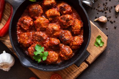 Mutfak masasının üzerinde tatlı ve ekşi domates soslu köfte. 