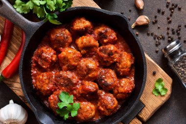 Mutfak masasının üzerinde tatlı ve ekşi domates soslu köfte. 